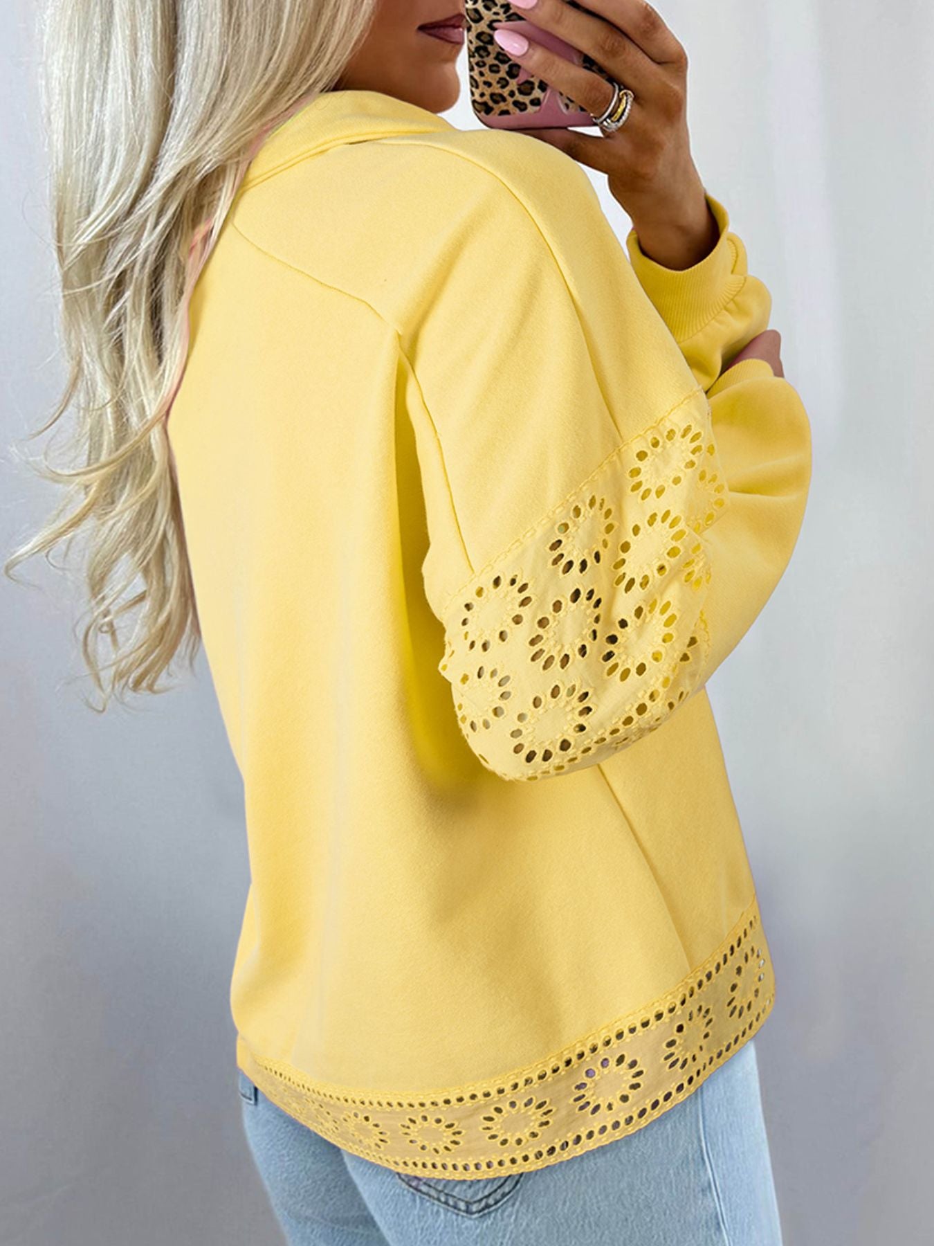 Yellow long-sleeve top with lace details worn by a person against a neutral background