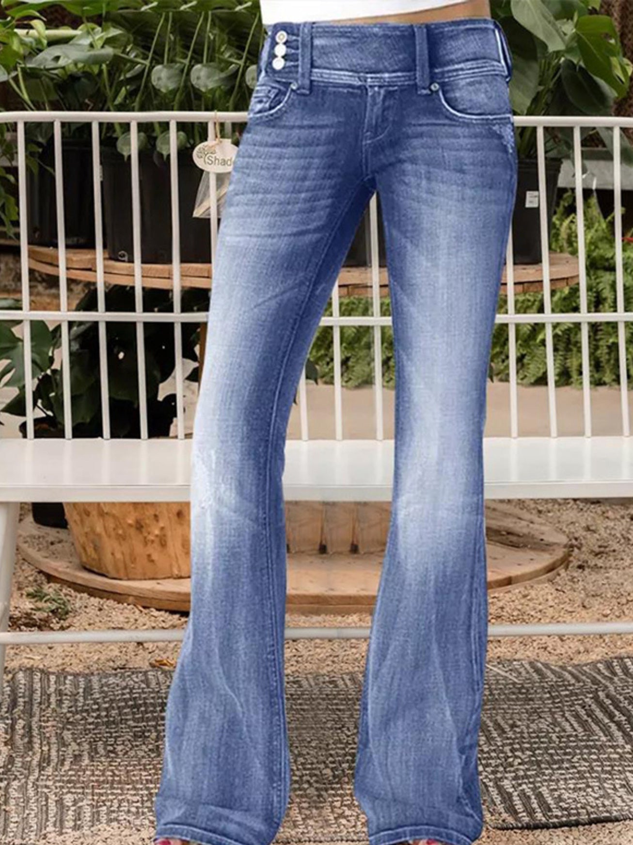 Woman wearing Vintage Wash Flare Jeans standing in front of botanical garde