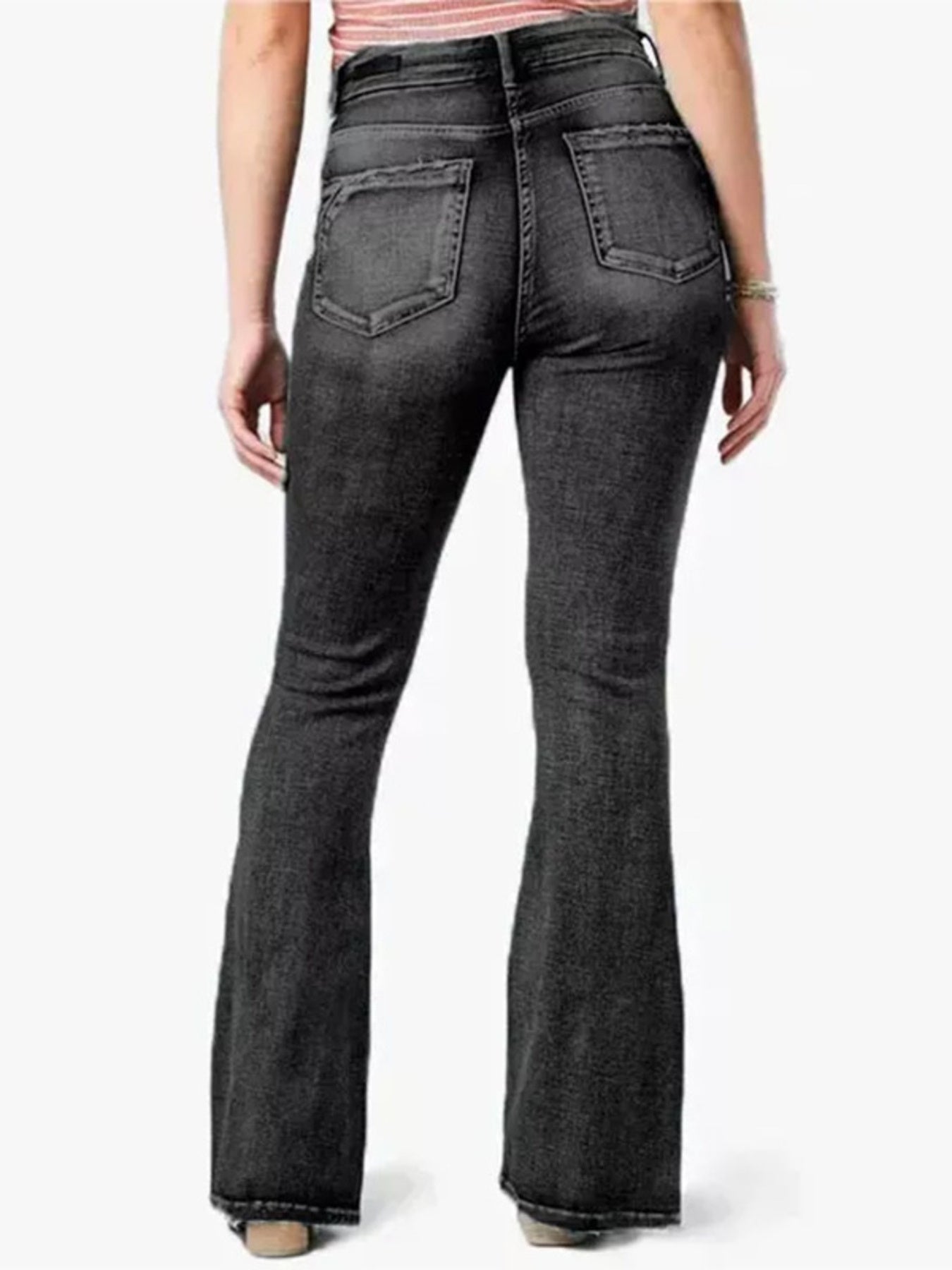 Black flared jeans worn by a person on a white background
